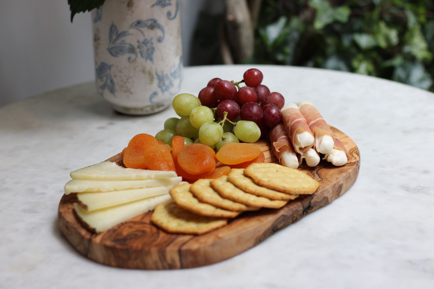 maman wooden board styled with cheese, fruit, and cold cuts — charcuterie board
