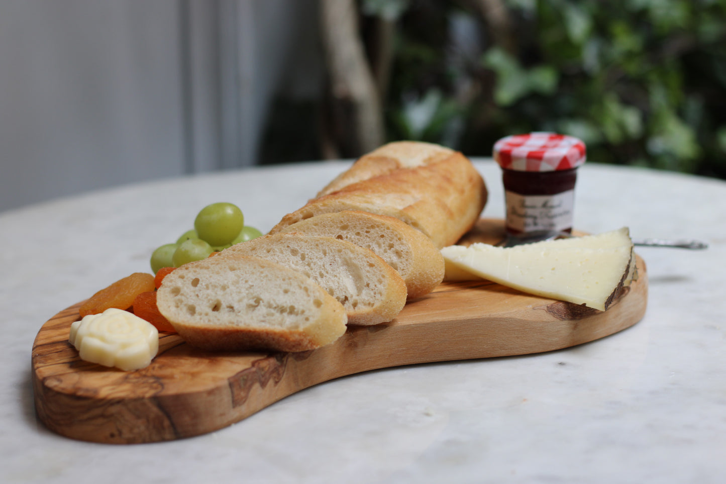 maman wooden board with cheese, fruit, and cold cuts — charcuterie styling angle view